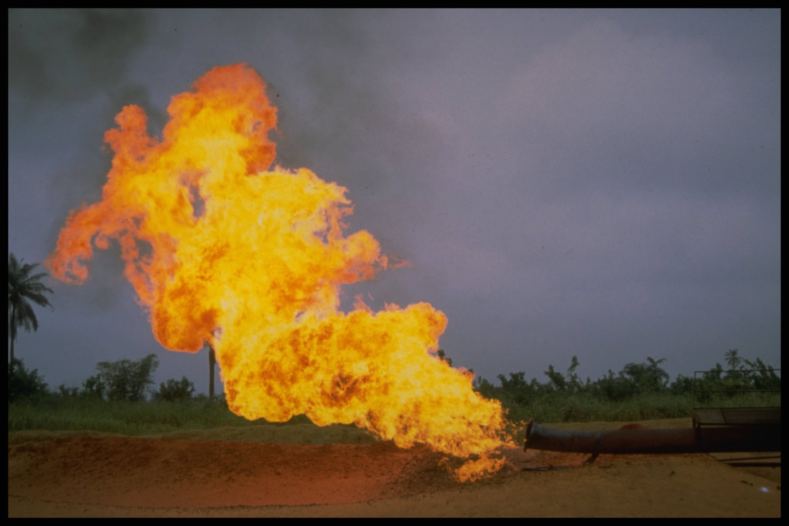 A fire flares out of an exhaust pipe at one of Shell’s oil fields in Bomo, Nigeria. Shell’s longstanding and treacherous history in the Niger Delta has plagued the region with disastrous oil spills and violent crackdowns against the local Ogoni people’s activism.